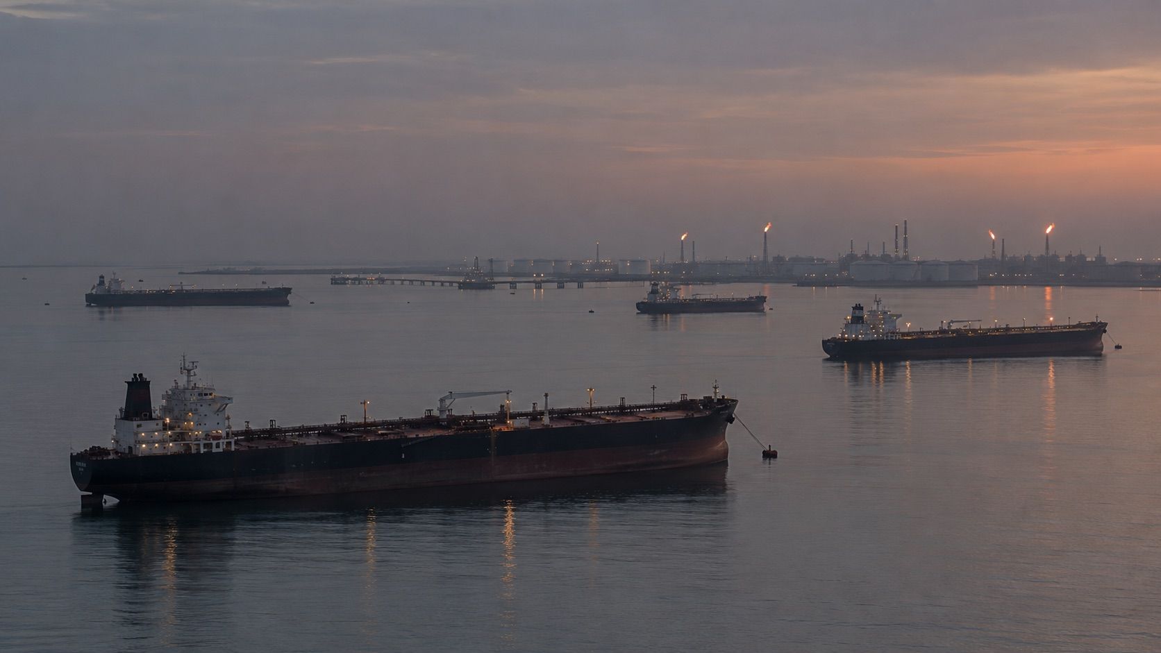 Crude tankers at anchor off an oil terminal at dusk